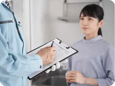 作業完了後に紙にチェックリストを記入している男性