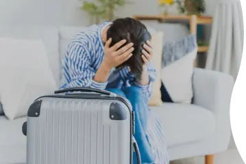 スーツケースを前に頭を抱えている女性